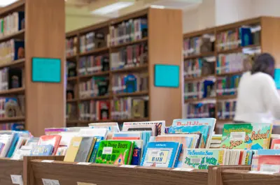 inside a Bryan library with aisles and shelves full of books
