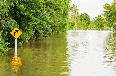 flooded street with high water levels nearly overtaking a street sign