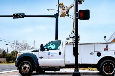 City of Bryan employee performing maintenance on a traffic signal light