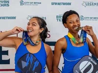 Two 2025 Games of Texas pickleball medalists showing off their awards.
