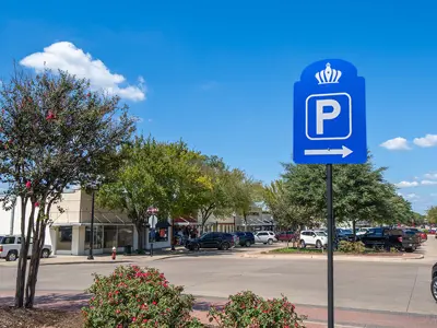 view down Main Street filled with parked vehicles behind a blue Bryan parking sign.
