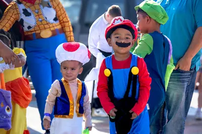 group of children dressed as characters for halloween at a trick or treating event.