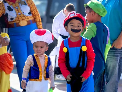 group of children dressed as characters for halloween at a trick or treating event.