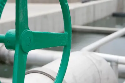 closeup of a pipe crank above wastewater treatment tanks