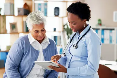 female physician reviewing documents and discussing with patient smiling